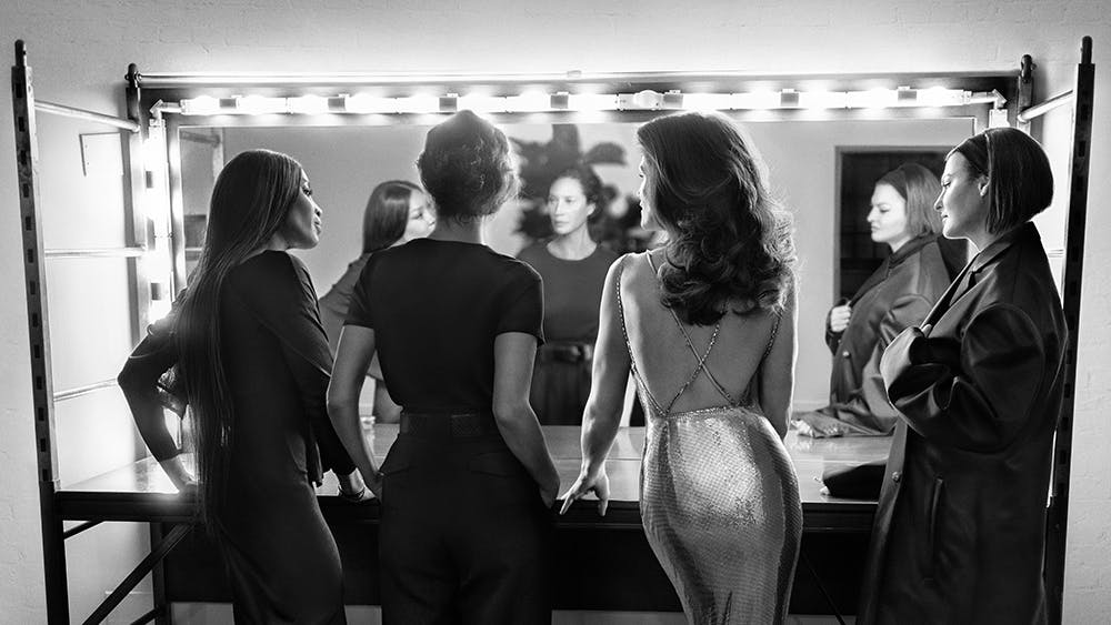 Linda Evangelista, Naomi Campbell, Christy Turlington, and Cindy Crawford stand in front of a mirror together